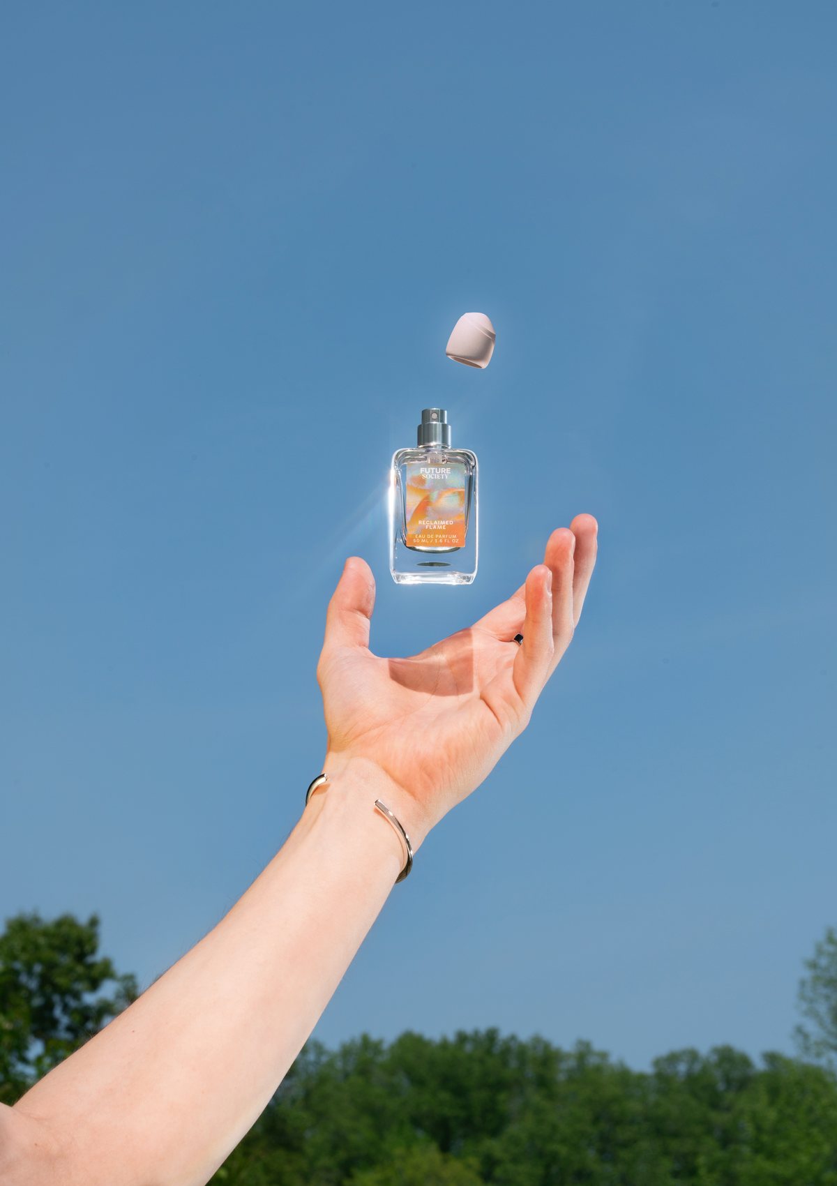 A Future Society bottle tossed against the blue sky